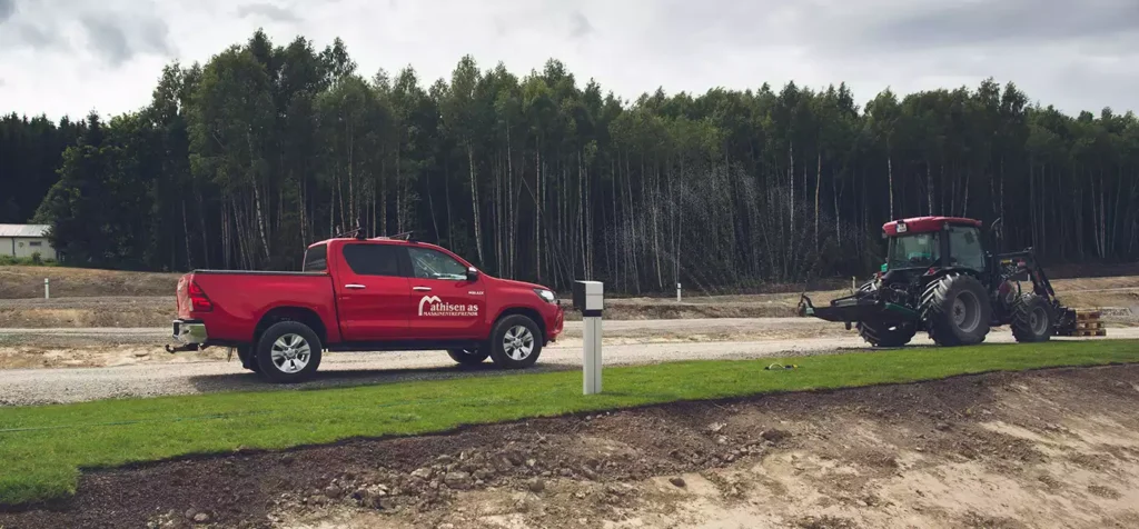 rød pickup og en traktor